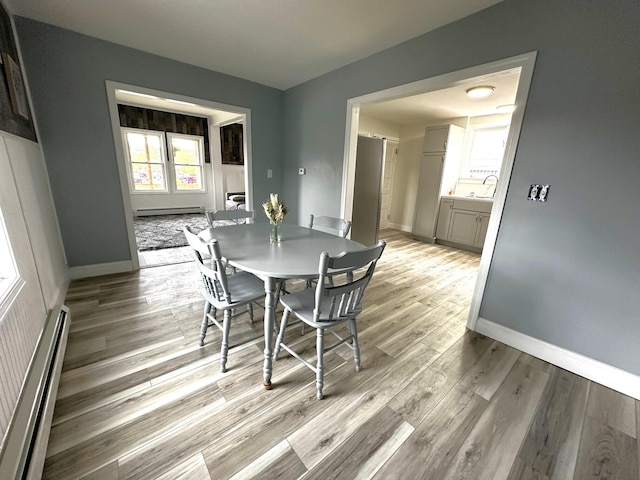507 Waldo St, Rumford, ME 04276 - dining space featuring a baseboard heating unit, light wood-style flooring, and baseboards