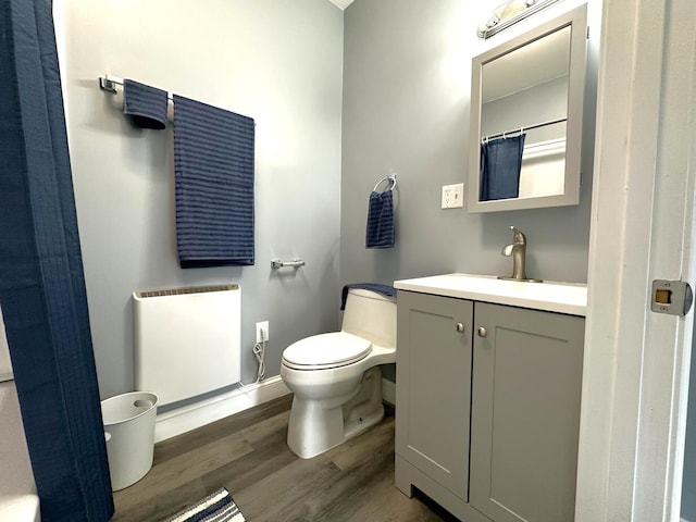 507 Waldo St, Rumford, ME 04276 - bathroom with wood finished floors, vanity, toilet, radiator, and baseboards
