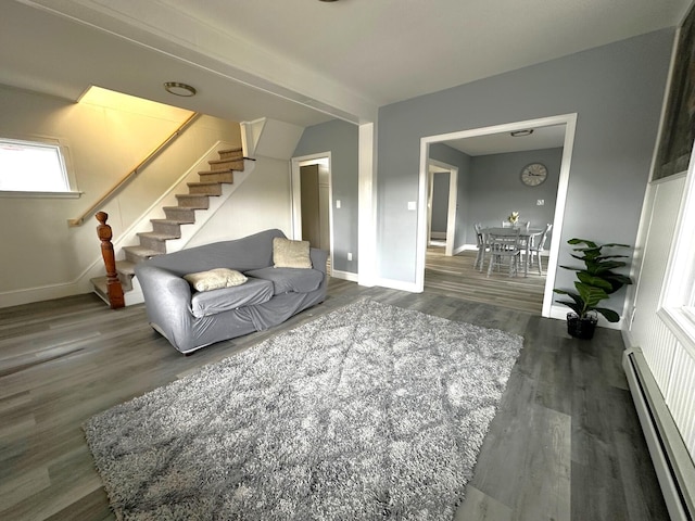 507 Waldo St, Rumford, ME 04276 - living area with baseboard heating, stairway, wood finished floors, and baseboards