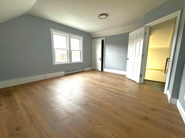 507 Waldo St, Rumford, ME 04276 - unfurnished bedroom featuring baseboard heating, vaulted ceiling, wood finished floors, and baseboards