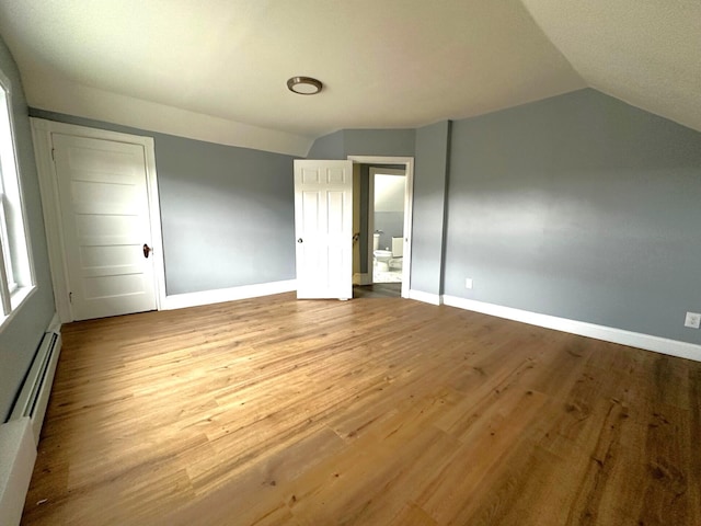 507 Waldo St, Rumford, ME 04276 - unfurnished bedroom featuring lofted ceiling, baseboards, wood finished floors, and baseboard heating