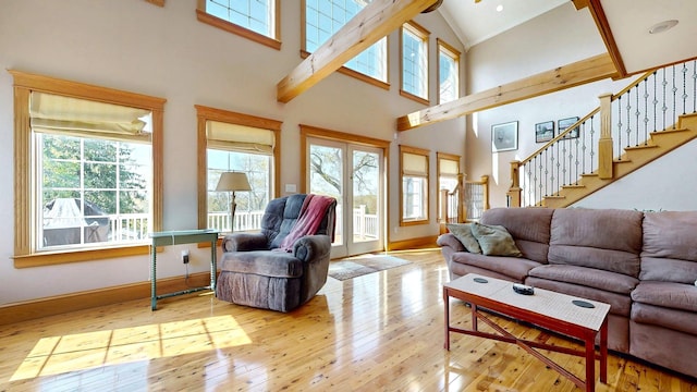 101 Parrott St, South Portland, ME 04106 - living area featuring healthy amount of natural light, hardwood / wood-style floors, high vaulted ceiling, stairway, and baseboards
