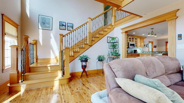 101 Parrott St, South Portland, ME 04106 - living area with hardwood / wood-style flooring, baseboards, stairs, a towering ceiling, and a chandelier