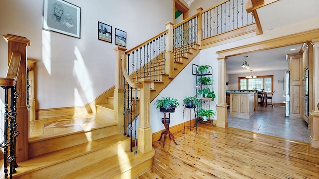 101 Parrott St, South Portland, ME 04106 - staircase with baseboards, wood finished floors, a chandelier, and a high ceiling