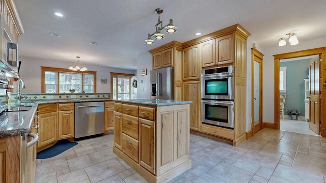 101 Parrott St, South Portland, ME 04106 - kitchen featuring appliances with stainless steel finishes, a chandelier, dark stone countertops, decorative light fixtures, and a peninsula