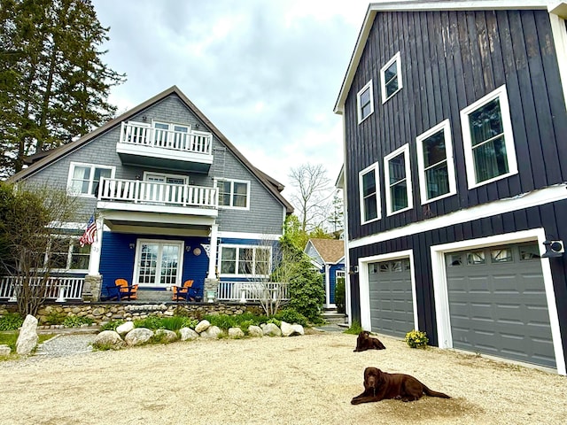 33 Latour St, Castine, ME 04421 - shingle-style home featuring a balcony, driveway, an attached garage, and board and batten siding