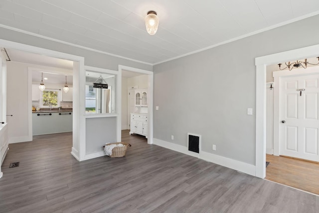 61 Granite St, Bath, ME 04530 - unfurnished bedroom with wood finished floors, crown molding, a chandelier, and baseboards