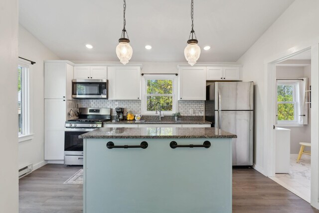 61 Granite St, Bath, ME 04530 - kitchen featuring appliances with stainless steel finishes, a center island, a baseboard heating unit, white cabinets, and healthy amount of natural light