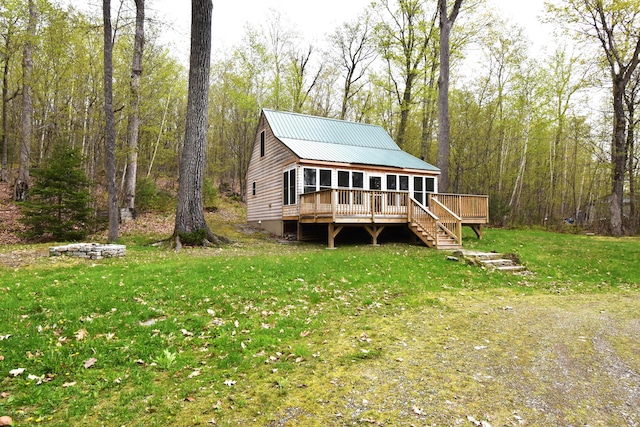 106 Shady Ln, Newport, ME 04953 - rear view of property with a wooden deck, a sunroom, a lawn, stairway, and metal roof