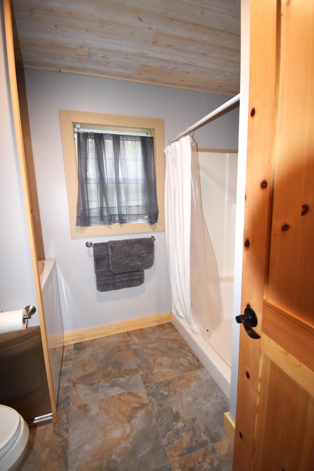 106 Shady Ln, Newport, ME 04953 - full bath with stone finish floors, curtained shower, baseboards, toilet, and wood ceiling