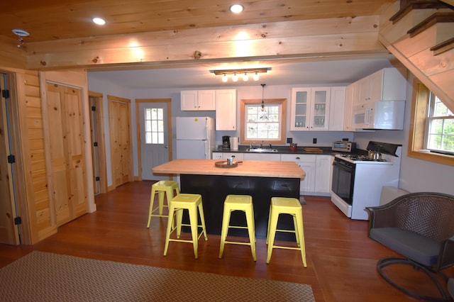 106 Shady Ln, Newport, ME 04953 - kitchen with white appliances, white cabinets, a breakfast bar, dark wood-type flooring, and recessed lighting