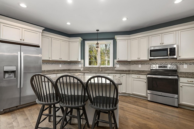 53 Ross Rd, Kennebunk, ME 04043 - kitchen featuring stainless steel appliances, a sink, tasteful backsplash, a breakfast bar area, and recessed lighting