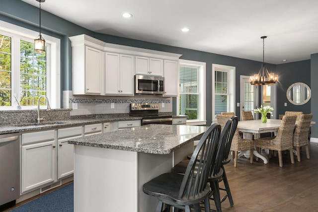 53 Ross Rd, Kennebunk, ME 04043 - kitchen with stainless steel appliances, a sink, a chandelier, white cabinetry, and backsplash