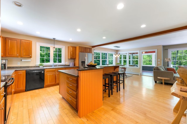400 Chopps Cross Rd, Woolwich, ME 04579 - kitchen with black appliances, a kitchen bar, a kitchen island, decorative light fixtures, and brown cabinetry