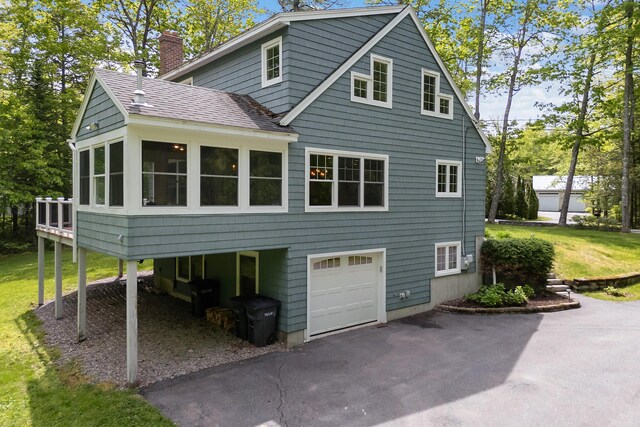 400 Chopps Cross Rd, Woolwich, ME 04579 - view of side of property featuring a garage, a chimney, driveway, a shingled roof, and a sunroom