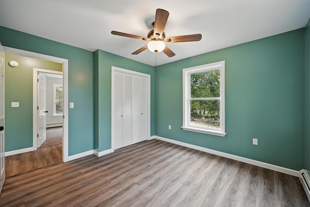 457 S Reynolds Rd, Winslow, ME 04901 - unfurnished bedroom with multiple windows, a closet, wood finished floors, and a baseboard heating unit