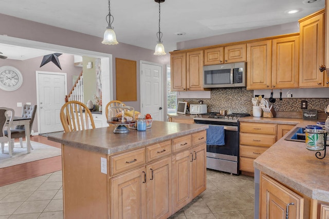 37 Birchwood Ln, Bowdoinham, ME 04008 - kitchen with stainless steel appliances, decorative backsplash, light tile patterned floors, a kitchen island, and recessed lighting