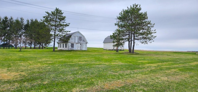 281 Cross Rd, Washburn, ME 04786 - view of green lawn with a barn and an outbuilding