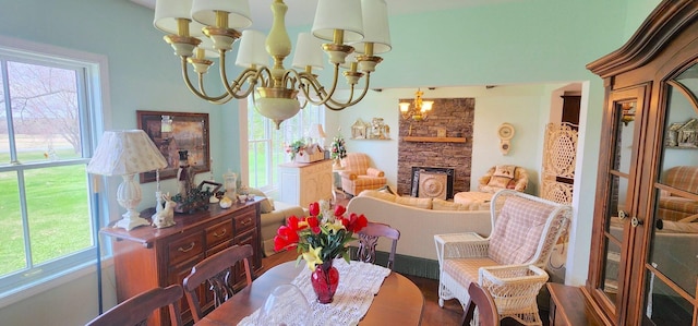 281 Cross Rd, Washburn, ME 04786 - dining room with a chandelier, healthy amount of natural light, and a stone fireplace
