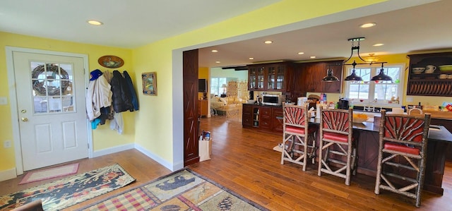 281 Cross Rd, Washburn, ME 04786 - kitchen featuring stainless steel microwave, wood finished floors, recessed lighting, glass insert cabinets, and decorative light fixtures