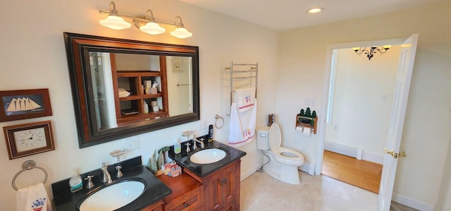 281 Cross Rd, Washburn, ME 04786 - full bathroom with a chandelier, double vanity, toilet, baseboards, and recessed lighting