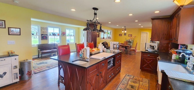 281 Cross Rd, Washburn, ME 04786 - kitchen featuring dark countertops, wood finished floors, a kitchen island, recessed lighting, and a sink