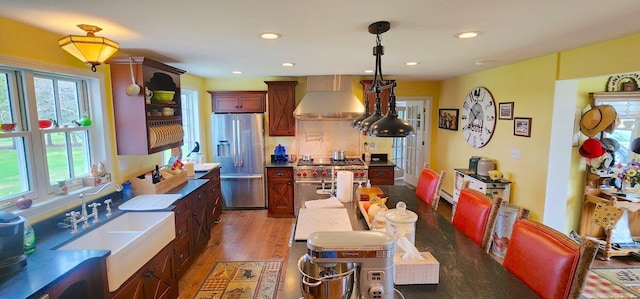 281 Cross Rd, Washburn, ME 04786 - kitchen with wall chimney range hood, stainless steel appliances, a sink, wood finished floors, and decorative backsplash