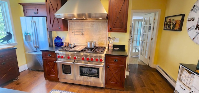 281 Cross Rd, Washburn, ME 04786 - kitchen featuring appliances with stainless steel finishes, extractor fan, a baseboard heating unit, dark wood-style flooring, and tasteful backsplash