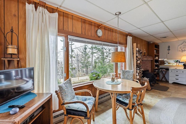 165 Mcfarland Shore Rd, Bristol, ME 04554 - dining area featuring wooden walls, a drop ceiling, a baseboard radiator, and light tile patterned floors