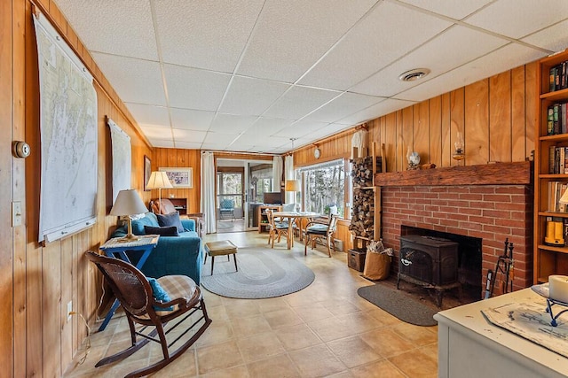 165 Mcfarland Shore Rd, Bristol, ME 04554 - living room with a wood stove, wooden walls, and a paneled ceiling