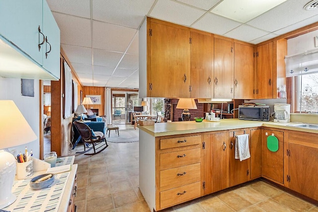 165 Mcfarland Shore Rd, Bristol, ME 04554 - kitchen with a drop ceiling, black microwave, plenty of natural light, light countertops, and brown cabinetry