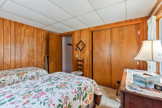 165 Mcfarland Shore Rd, Bristol, ME 04554 - bedroom featuring wood walls, a closet, light tile patterned floors, and a drop ceiling
