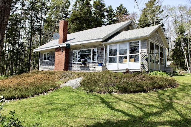 165 Mcfarland Shore Rd, Bristol, ME 04554 - view of front of house featuring a chimney, a front lawn, a sunroom, and roof with shingles