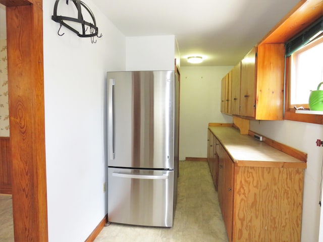 204 Clark Island Rd, Saint George, ME 04859 - kitchen featuring freestanding refrigerator, light countertops, baseboards, light flooring, and brown cabinetry