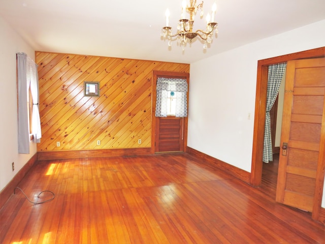 204 Clark Island Rd, Saint George, ME 04859 - empty room featuring baseboards, a chandelier, hardwood / wood-style floors, and wooden walls