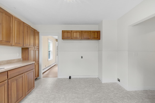 606 Main St, Sanford, ME 04083 - kitchen with light flooring, a baseboard radiator, light countertops, brown cabinetry, and baseboards