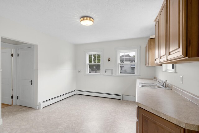 606 Main St, Sanford, ME 04083 - kitchen with a sink, brown cabinetry, baseboard heating, and light countertops