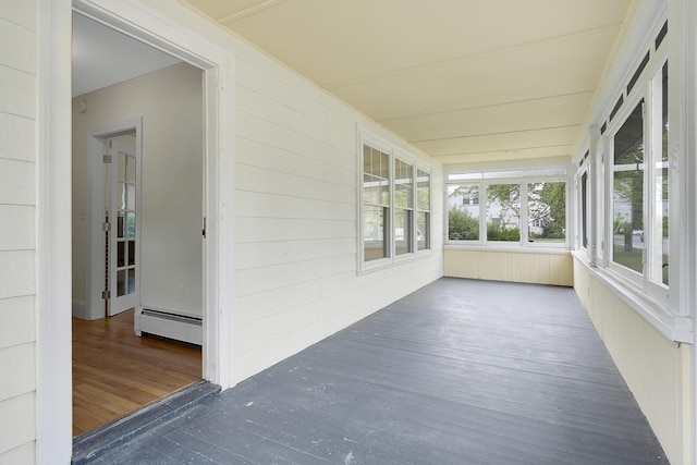 606 Main St, Sanford, ME 04083 - unfurnished sunroom featuring baseboard heating, wood finished floors, and wooden walls