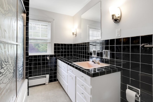606 Main St, Sanford, ME 04083 - bathroom with tile walls, baseboard heating, plenty of natural light, tile patterned floors, and vanity