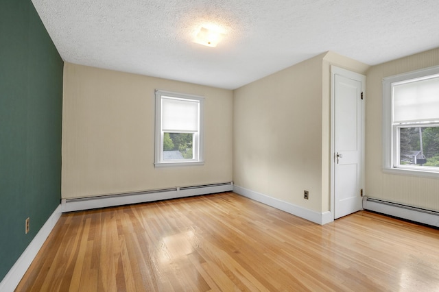 606 Main St, Sanford, ME 04083 - spare room with a baseboard radiator, light wood-style floors, baseboards, and a textured ceiling