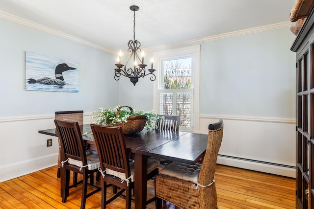 11 Summer St, Kennebunk, ME 04043 - dining room featuring a baseboard radiator, ornamental molding, a chandelier, light wood-type flooring, and a wainscoted wall