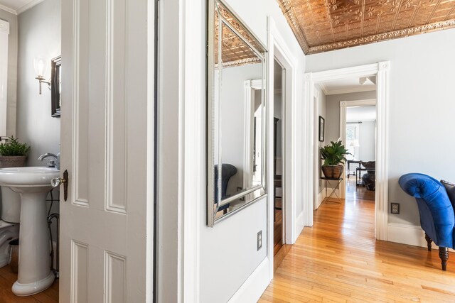 11 Summer St, Kennebunk, ME 04043 - corridor with light wood-type flooring, ornamental molding, an ornate ceiling, baseboards, and a sink