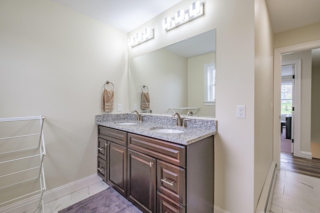 14 Bluebird Trl Unit 67, Falmouth, ME 04105 - bathroom with a baseboard heating unit, double vanity, and baseboards