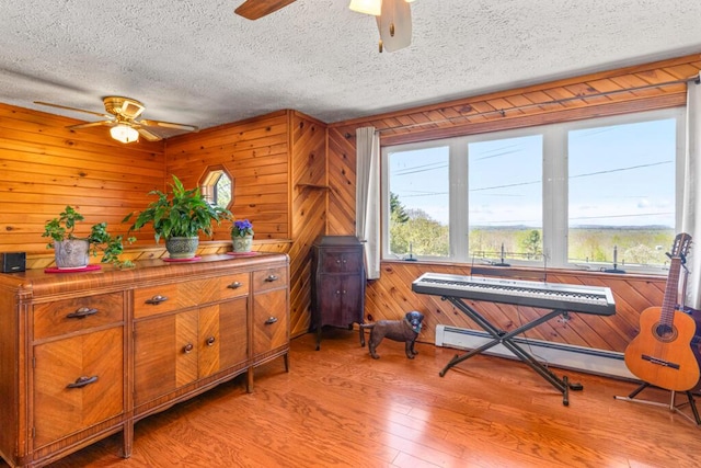 414 Oak Hill Rd, Litchfield, ME 04350 - living area featuring a ceiling fan, light wood-type flooring, plenty of natural light, a textured ceiling, and wooden walls