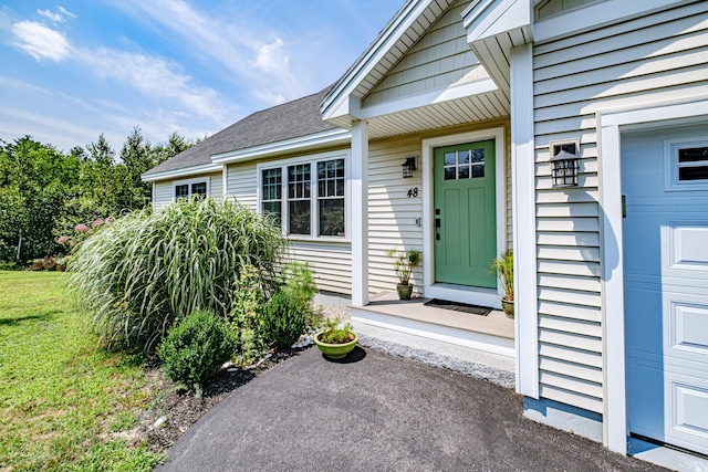 48 Sancho Dr, Saco, ME 04072 - doorway to property with a yard, roof with shingles, and a garage