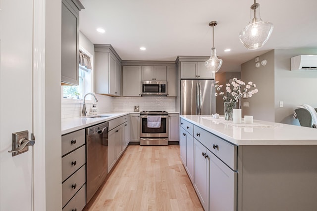 48 Sancho Dr, Saco, ME 04072 - kitchen featuring stainless steel appliances, gray cabinetry, a sink, a wall unit AC, and light wood-style floors