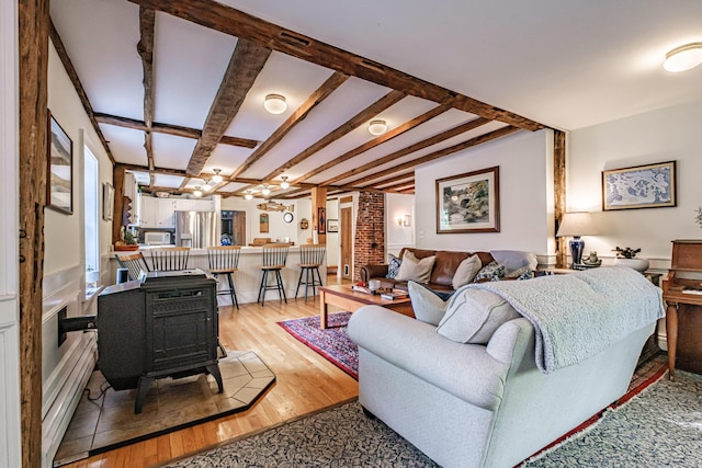 71 Brook Rd, Falmouth, ME 04105 - living room with light wood-type flooring, a wood stove, and beam ceiling