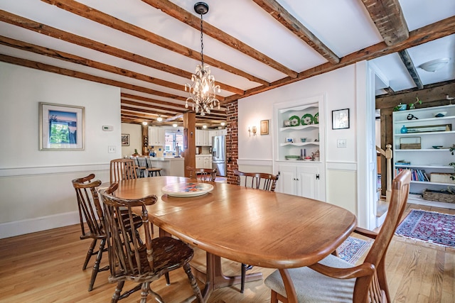 71 Brook Rd, Falmouth, ME 04105 - dining space with light wood-type flooring, a chandelier, beamed ceiling, built in features, and baseboards