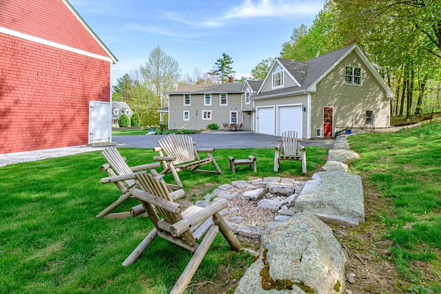 71 Brook Rd, Falmouth, ME 04105 - back of property with a garage, asphalt driveway, and a lawn