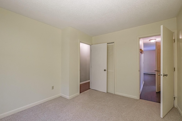 55 Reservoir Rd, Paris, ME 04281 - unfurnished bedroom with a baseboard heating unit, light colored carpet, a closet, baseboards, and a textured ceiling